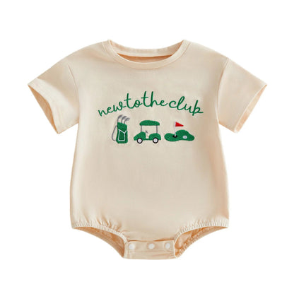 Front view of the Kidsely "New to the Club" baby golf romper in cream, featuring a green golf cart, clubs, and putting green graphic.