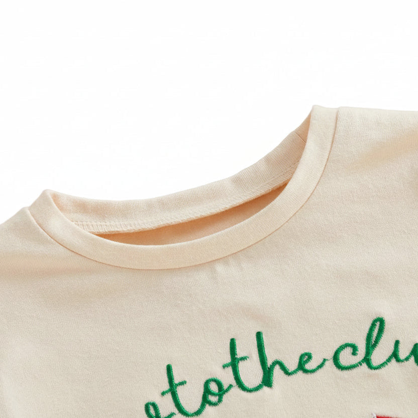 Close-up detail of the smooth, rounded crew neckline on the cream cotton baby golf romper.