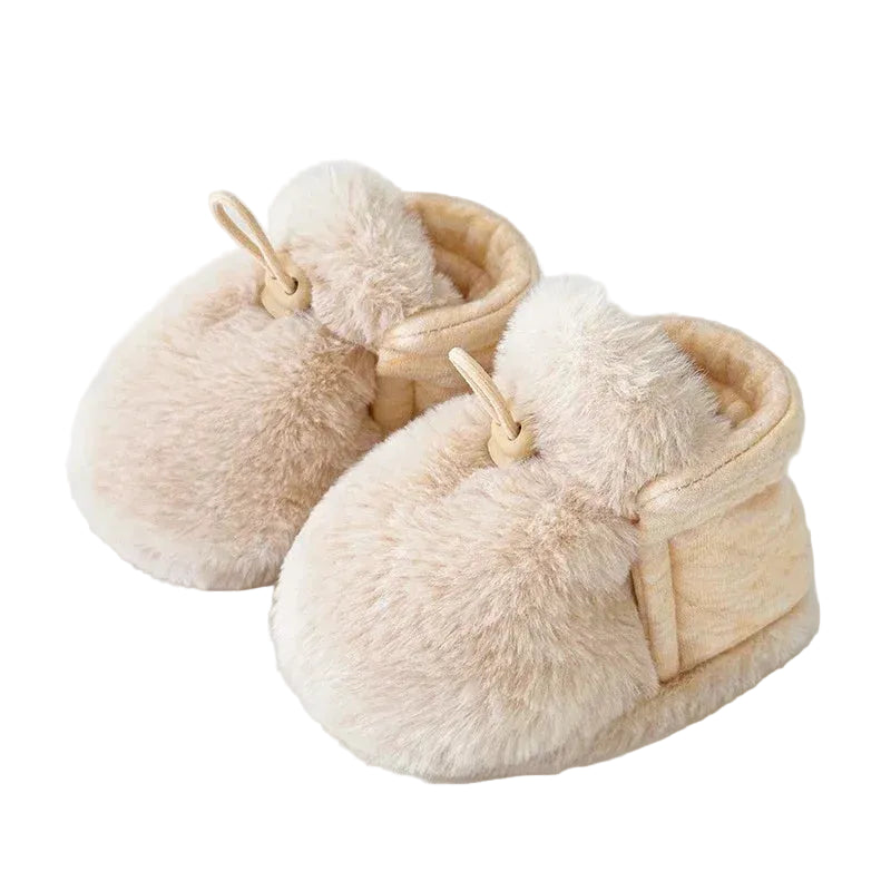 A pair of beige newborn first walker fleece crib shoes on a white background.