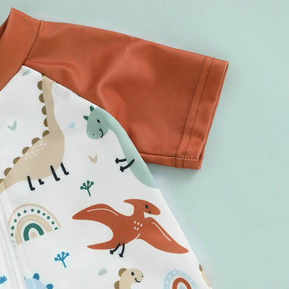 Detailed view of the non-pilling 100% polyester fabric showing the muted sage green, tan, and rust dinosaur and rainbow print.