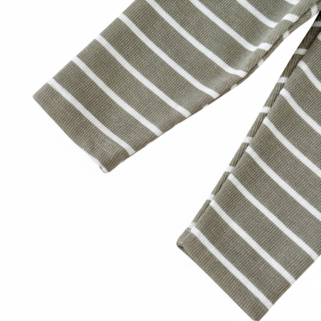 Close-up of the ankle hems on olive green and white striped baby and toddler pants.