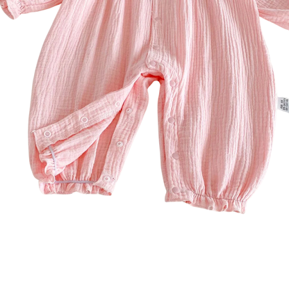 Close-up of the open inseam snap closures on the pink baby bubble romper for easy diaper changes.