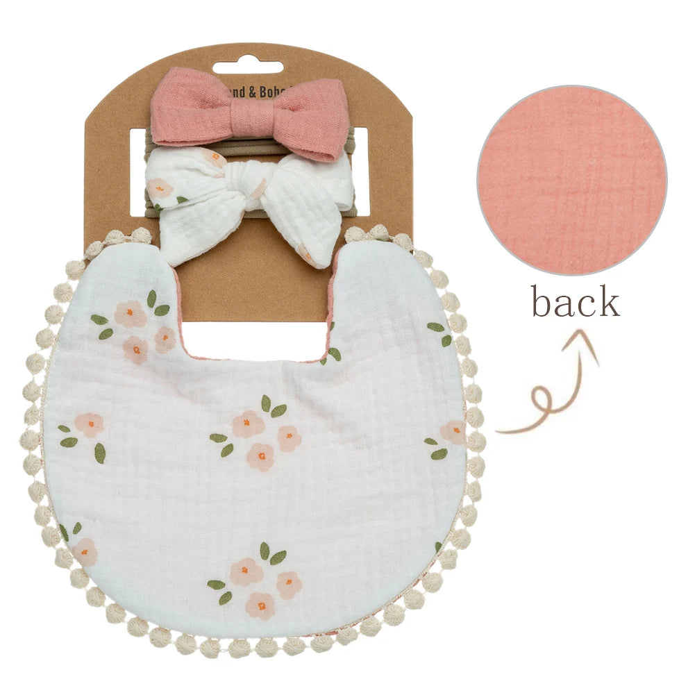 Large peach blossom floral muslin bib on white background with coral pink reversible side.