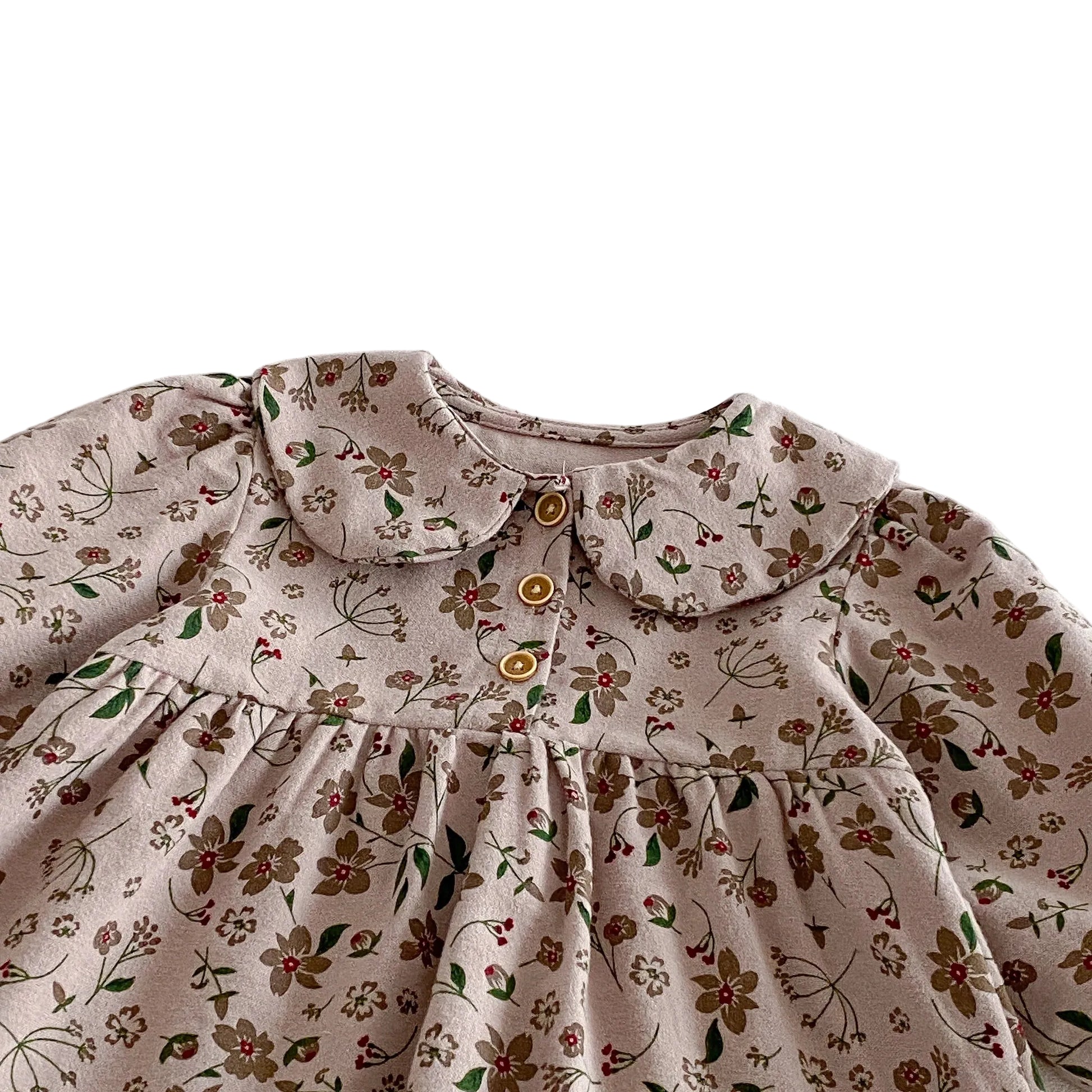 Close-up of the classic Peter Pan collar, gently gathered chest, and wooden-style front buttons on the floral toddler dress.