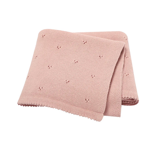 Pink knitted cotton blanket with small pointelle pattern on a white background