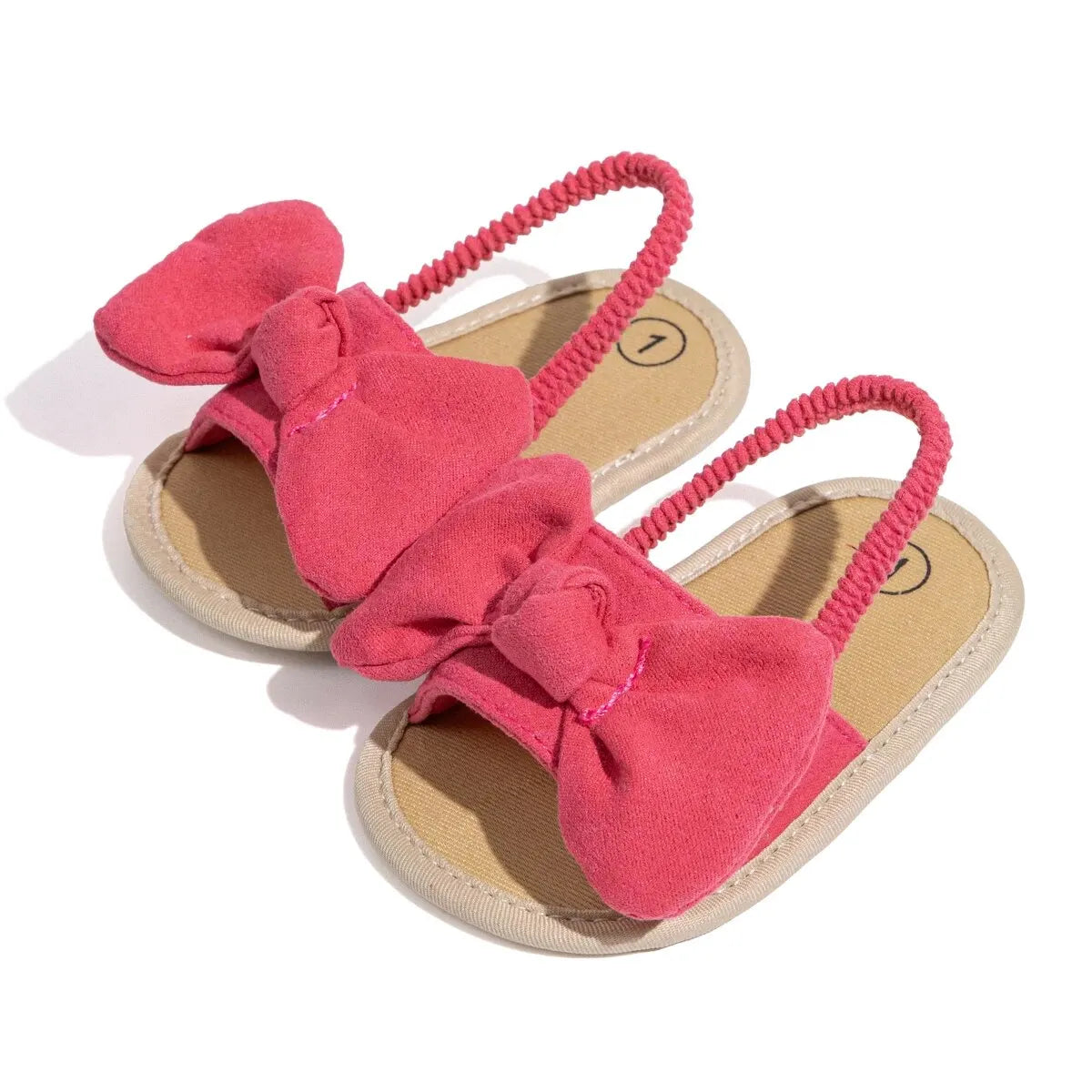 Pair of pink baby girl soft sole sandals featuring an oversized brushed fabric bow and elastic slingback strap.