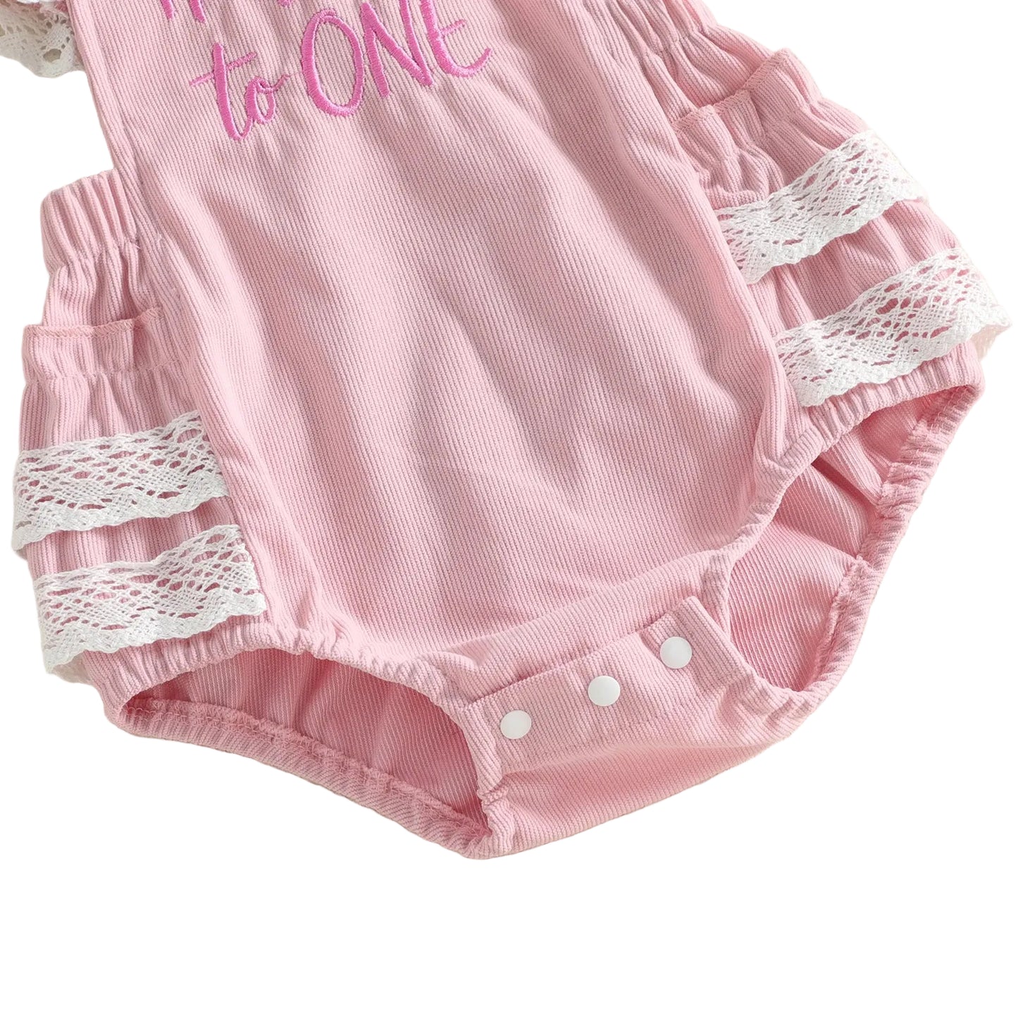 Close-up of the bottom of the pink baby girl romper showing the convenient snap closures for easy diaper changes.