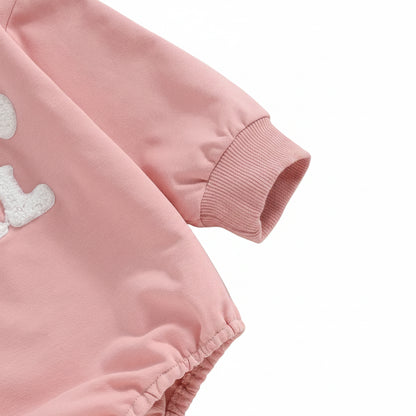 Close-up of the long sleeve and ribbed cuff on the pink baby sweatshirt bubble romper.