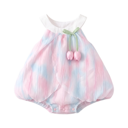 Studio flat lay of the pink and blue pastel iridescent baby girl tulip romper dress on a white background.