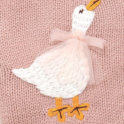 Close-up of the white embroidered goose with a 3D pink tulle bow and yellow feet on a pink knit cardigan.