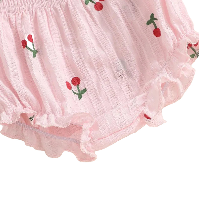 Close-up detail of the pink baby girl shorts with an elastic waistband, leg ruffles, and cherry print.