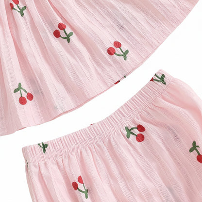 Detailed close-up showing the soft, textured striped cotton fabric of the pink baby outfit and the red cherry print.