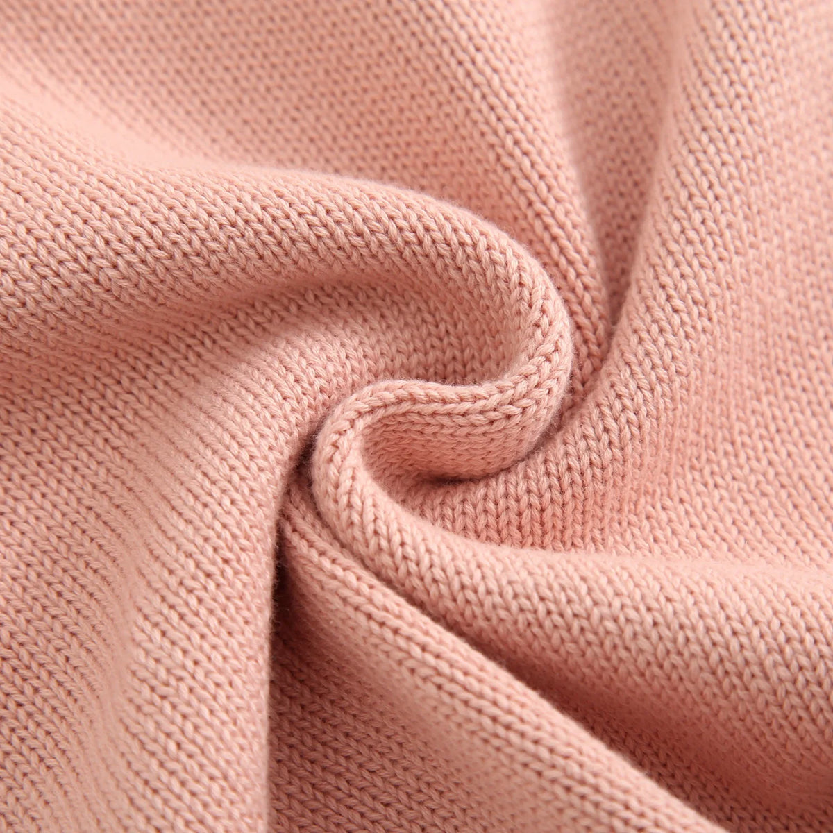 Macro close-up view of the soft pink cotton blend cable knit fabric texture.