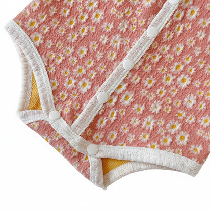 Close-up of the bottom snap closures and elastic leg openings on the pink baby bubble romper.