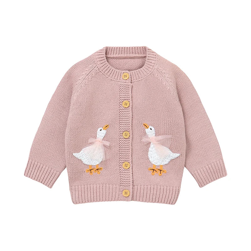 Pink baby and toddler girls knit cardigan sweater featuring two embroidered geese with pink tulle bows, flat lay on white background.