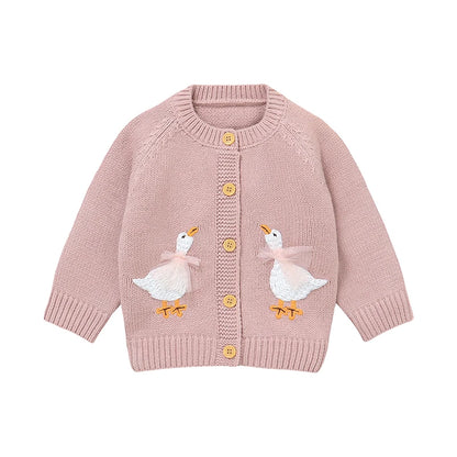 Pink baby and toddler girls knit cardigan sweater featuring two embroidered geese with pink tulle bows, flat lay on white background.