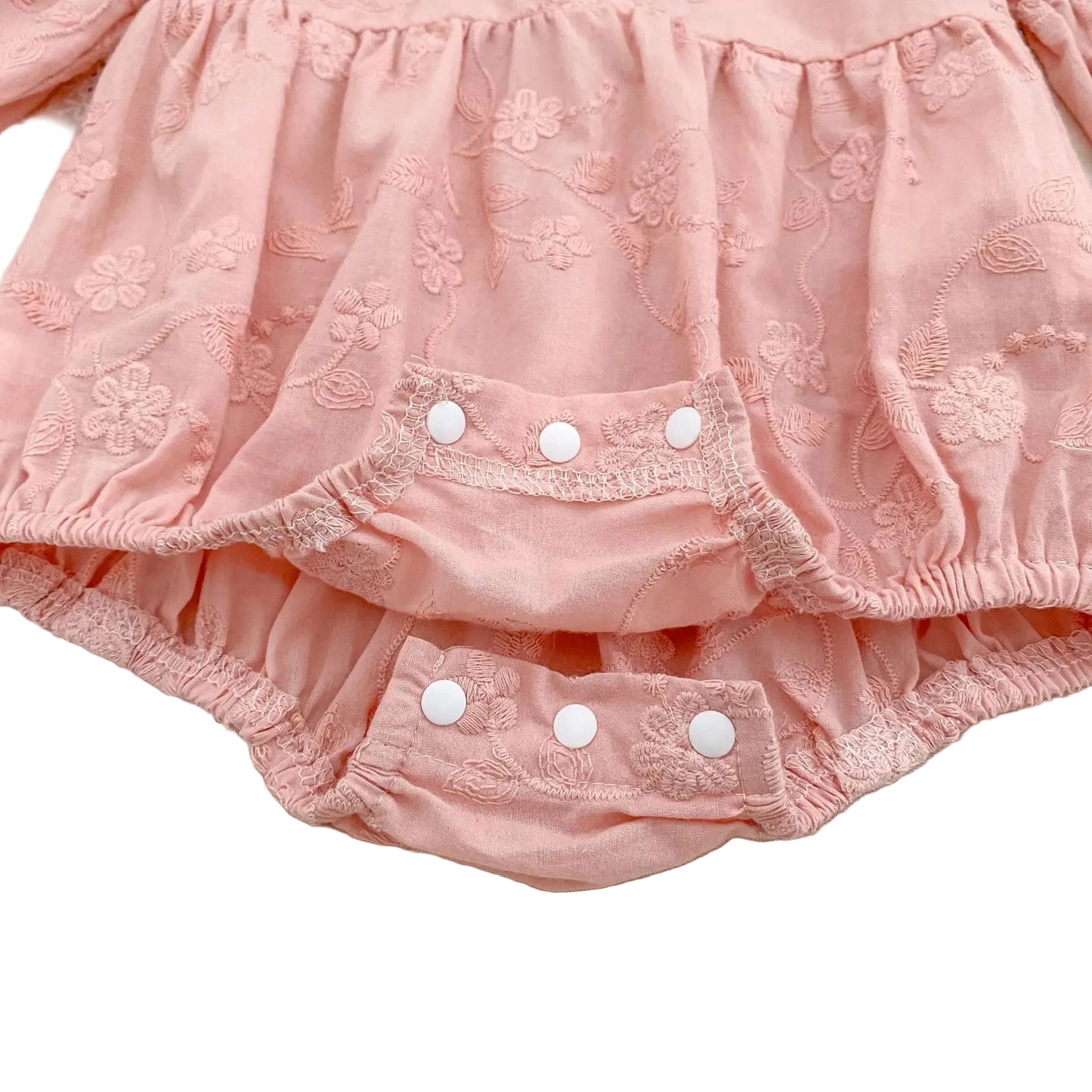 Close-up of the convenient open bottom snap closures on a pink baby girl bubble romper.