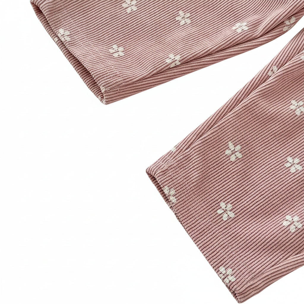 Close-up of the bottom pant leg hem on pink floral corduroy toddler overalls.
