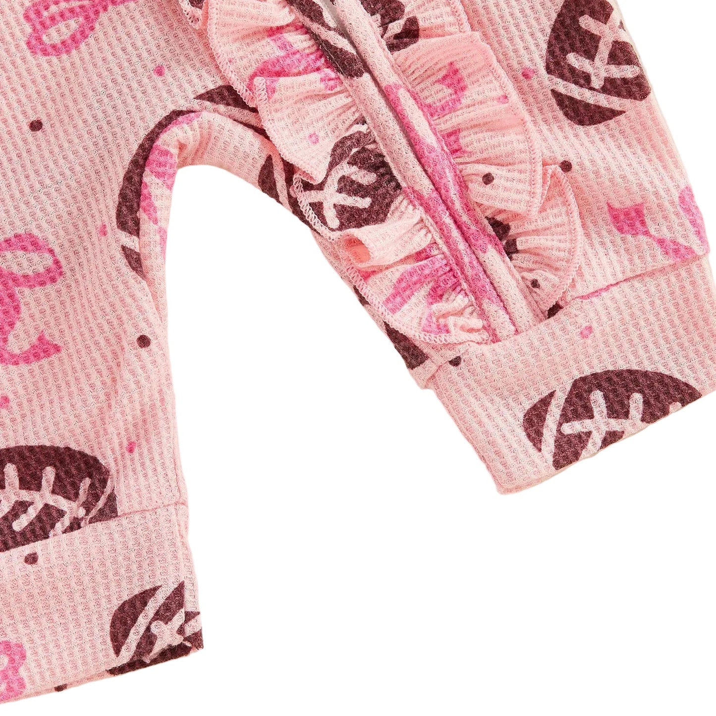 Back view of the pink baby girl long-sleeve jumpsuit and matching bow headband, showing the all-over football pattern.