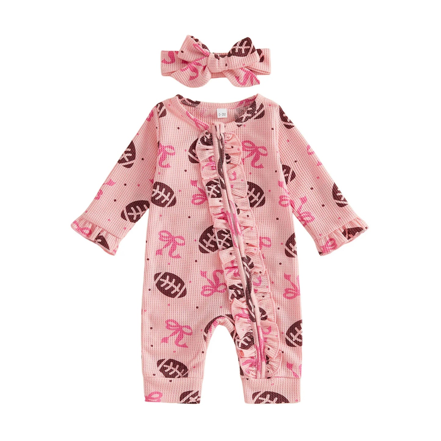 Front view of a pink waffle-knit baby girl romper with football and bow print, featuring a ruffle zipper and matching headband on a white background.