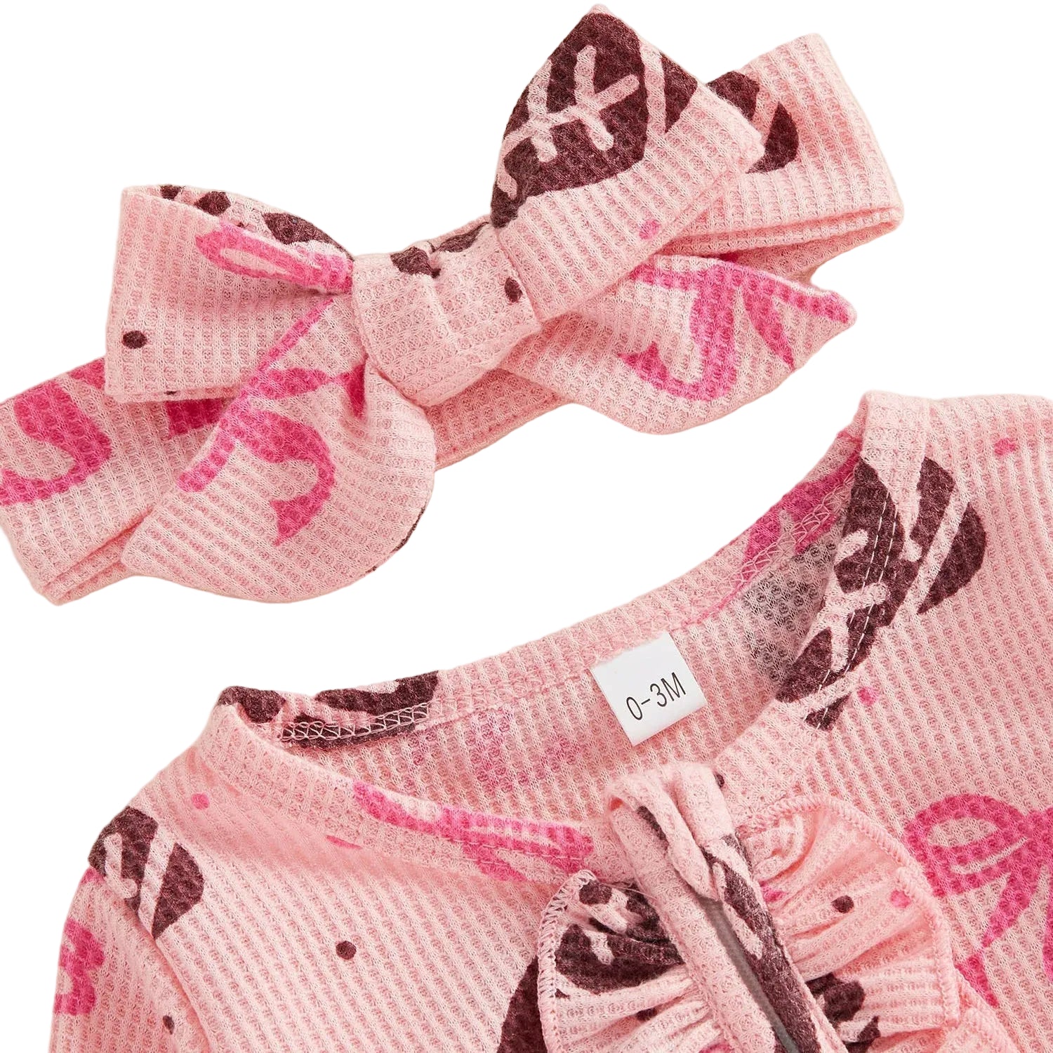 Close-up of the matching pink bow headband and the round neckline of the waffle-knit football baby jumpsuit.