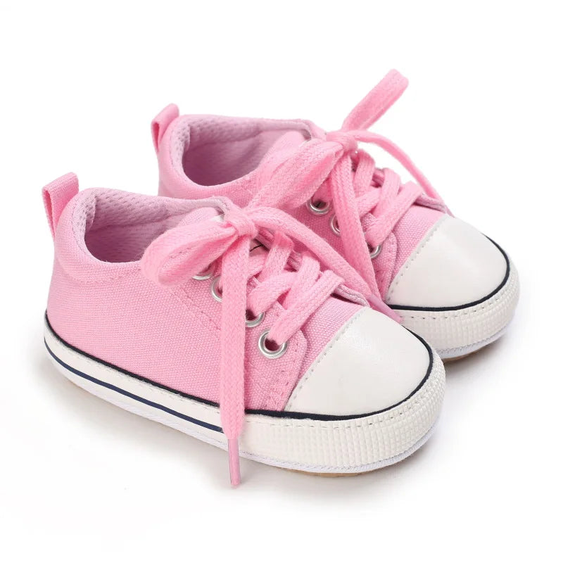 Soft pink infant athletic sneakers for baby girls, featuring a durable canvas upper.