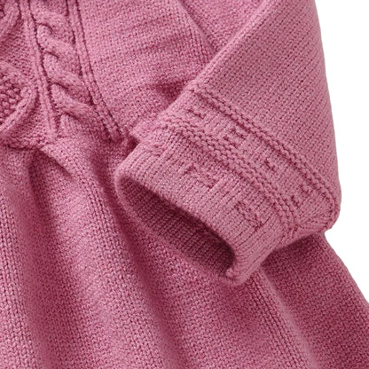 Close-up of the long sleeve cuff and cable knit pattern on a pink toddler sweater dress.