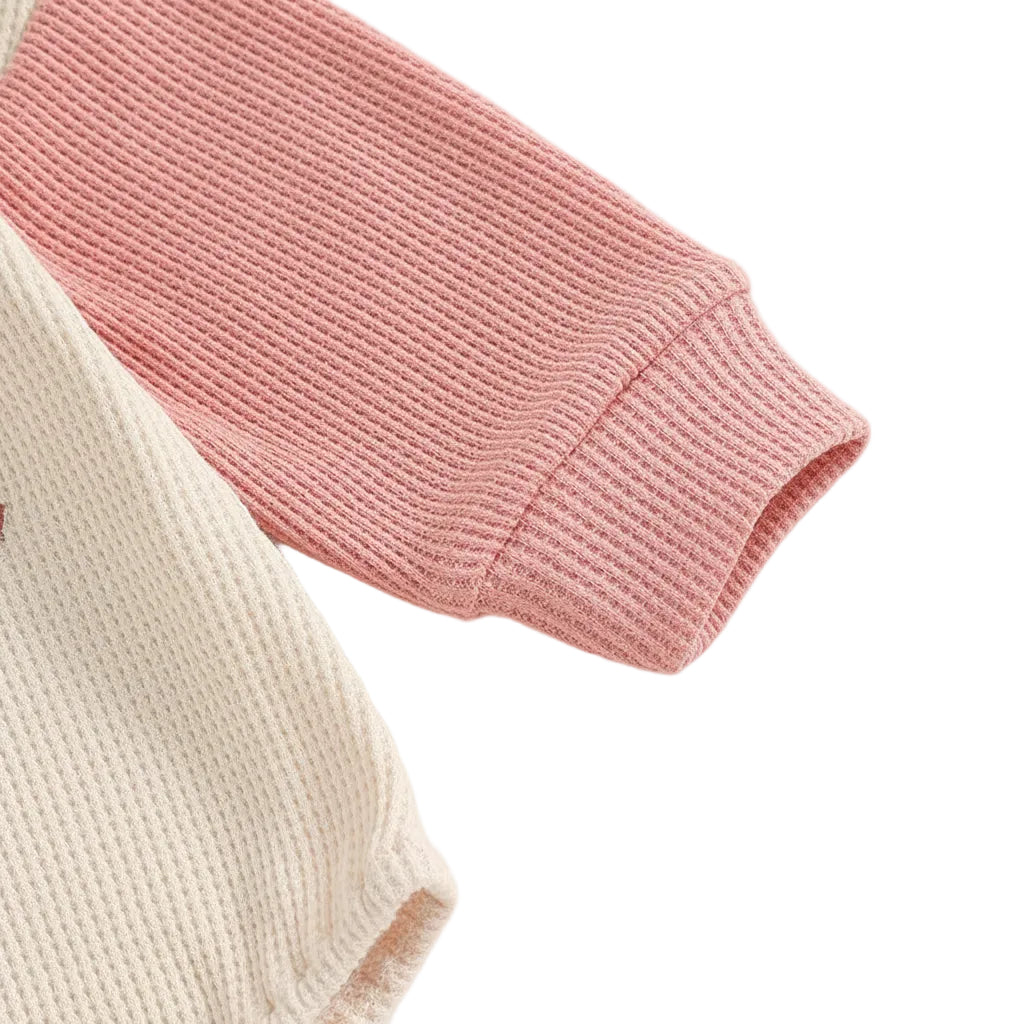 Close up of the soft pink long sleeve cuff on the baby girl raglan bodysuit.