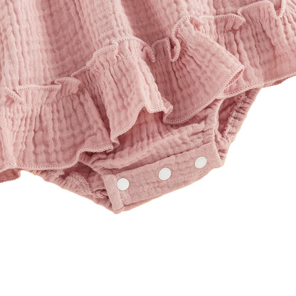 Close-up showing the convenient bottom snap closure and delicate ruffled leg trim on the pink strawberry baby romper.