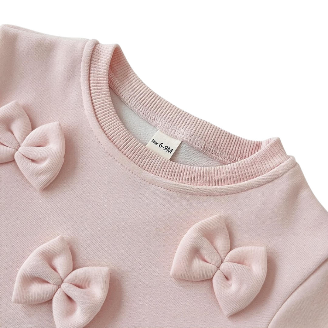 Close-up detail of the crew neckline and soft pink 3D bows securely attached to the toddler girl pullover sweatshirt.