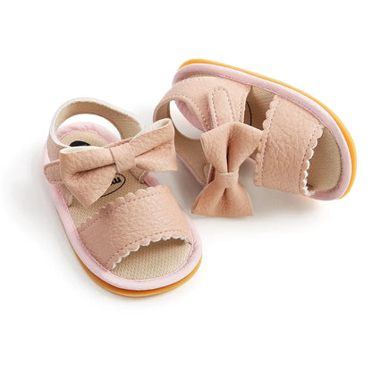 Top-down angled shot of a pair of pink leather toddler girl summer sandals showing the inner cushioned lining and flexible rubber outsole rim.