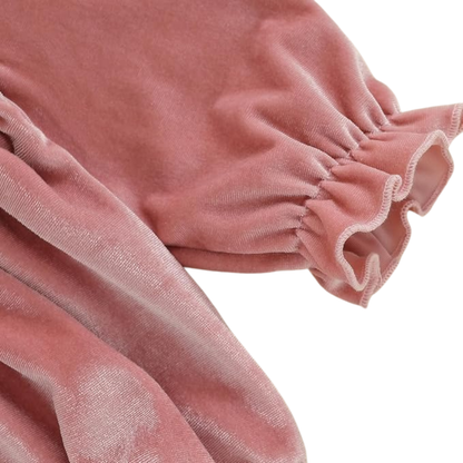 Close-up of long sleeve elastic ruffled wrist cuff on baby pink velvet bubble romper