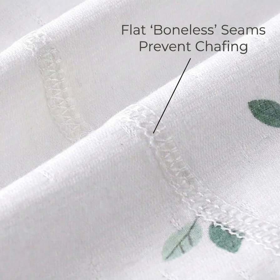 Macro view of the flat-lock stitched inner seams on the white pure cotton baby clothing, pointing out that flat boneless seams prevent chafing.