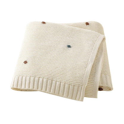 Creamy Oat Milk white 100% cotton knitted baby blanket showing the detailed popcorn stitch and soft texture.
