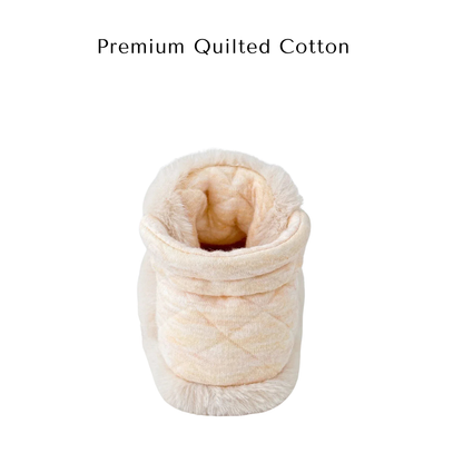 A top-down look inside a beige baby bootie showcasing the premium quilted cotton lining.