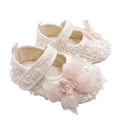 Pair of Kidsely antique white baby girl princess first walker shoes with floral 3D petals and tulle bow.