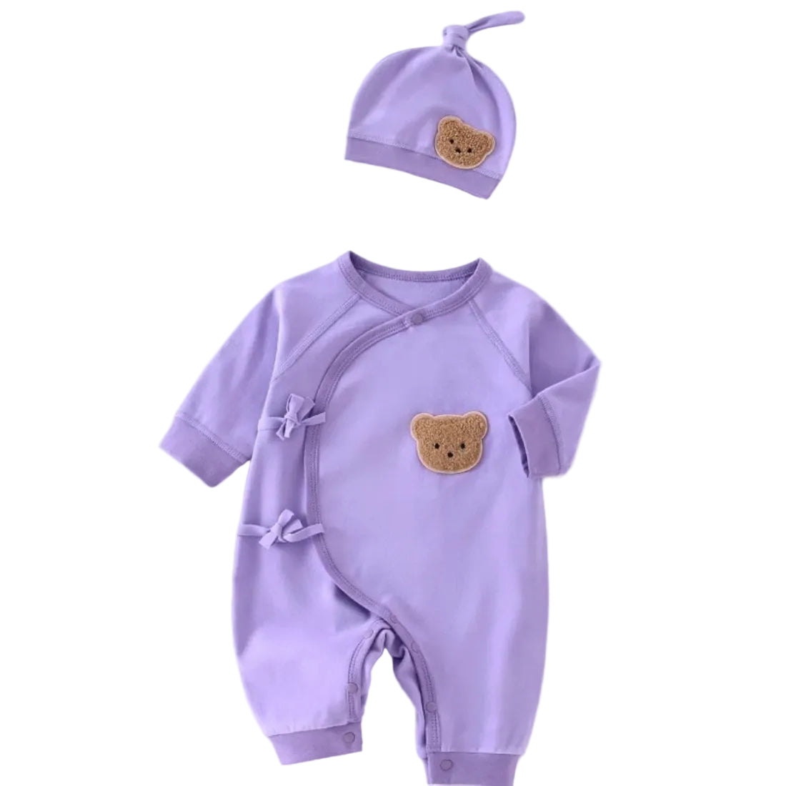Flat lay of a purple newborn kimono romper with side ties and matching knotted hat, featuring textured teddy bear patches.