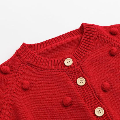 Close up of the red baby cardigan highlighting the ribbed crew neckline and front button closure.