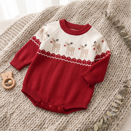 Red baby Christmas reindeer romper laid on a textured knit blanket next to a wooden teething toy.