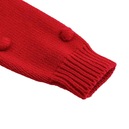 Close up of the red cotton knit baby sweater showing the long sleeve and ribbed cuff detail.