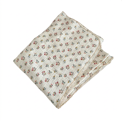 Folded red ditsy floral 2-layer cotton muslin swaddle blanket on a pure white background.