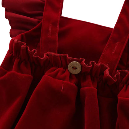 Close-up of the gathered elastic back waistband and decorative wooden button on the red baby holiday romper.