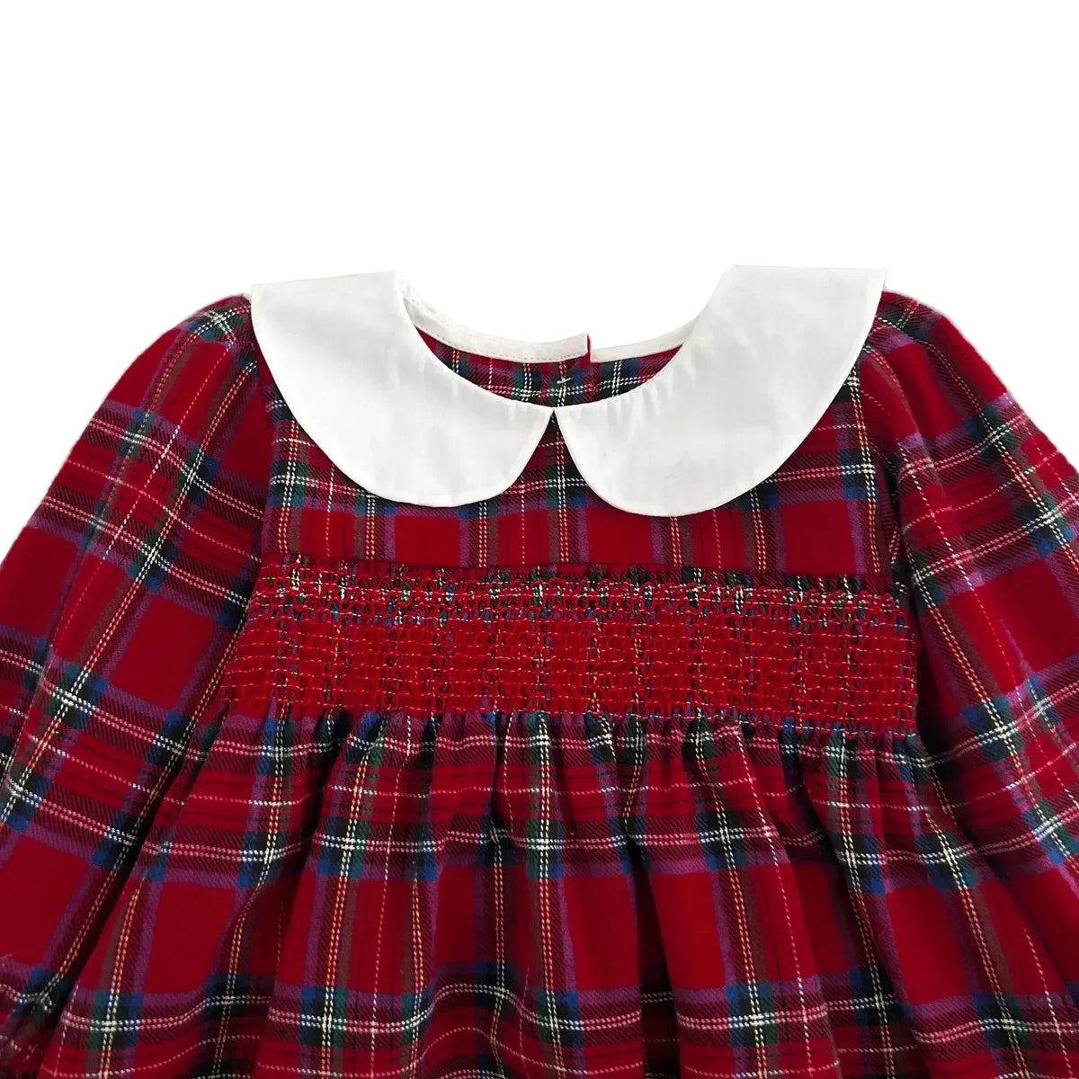 Close-up of white Peter Pan collar and intricate red smocking on baby girl Christmas outfit