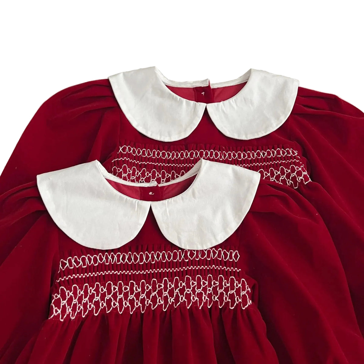 Close-up of the intricate chest smocking and crisp white Peter Pan collars on the matching red holiday outfits.
