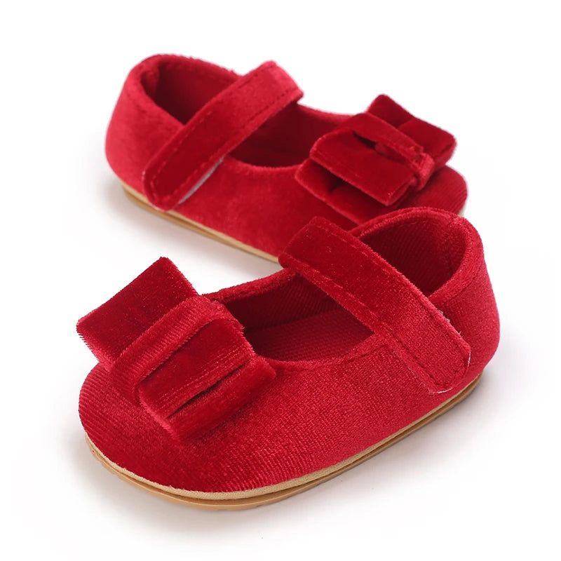 Side view of red velvet baby girl Mary Jane shoes featuring bow accent for holiday outfits