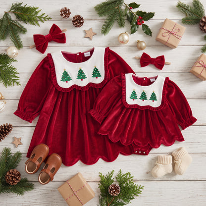 Matching red velvet Christmas dress and baby romper dress flat lay with white embroidered tree collars and hair bows