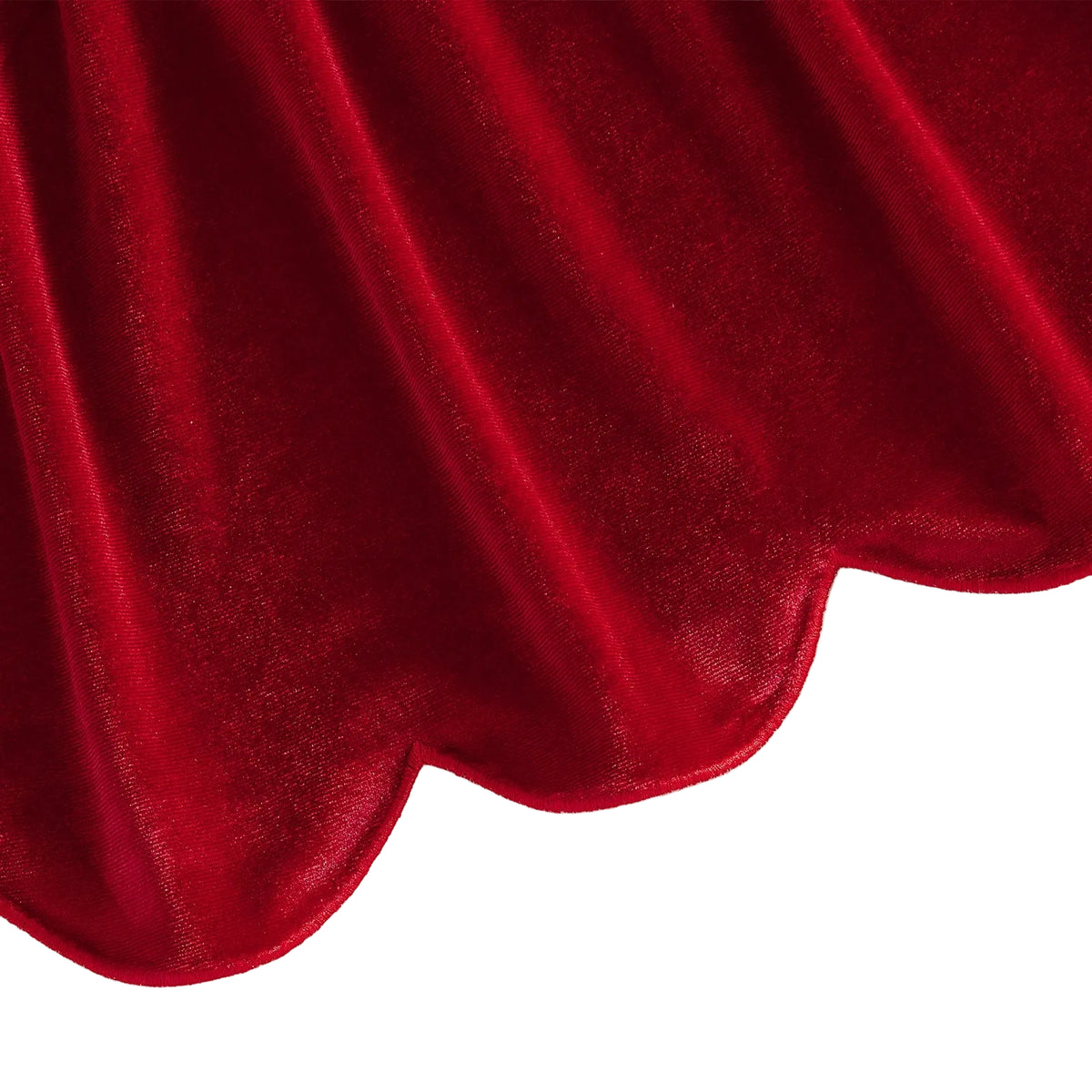 Detail view of the flared scalloped bottom hemline on the red velvet toddler dress