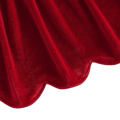 Detail view of the flared scalloped bottom hemline on the red velvet toddler dress