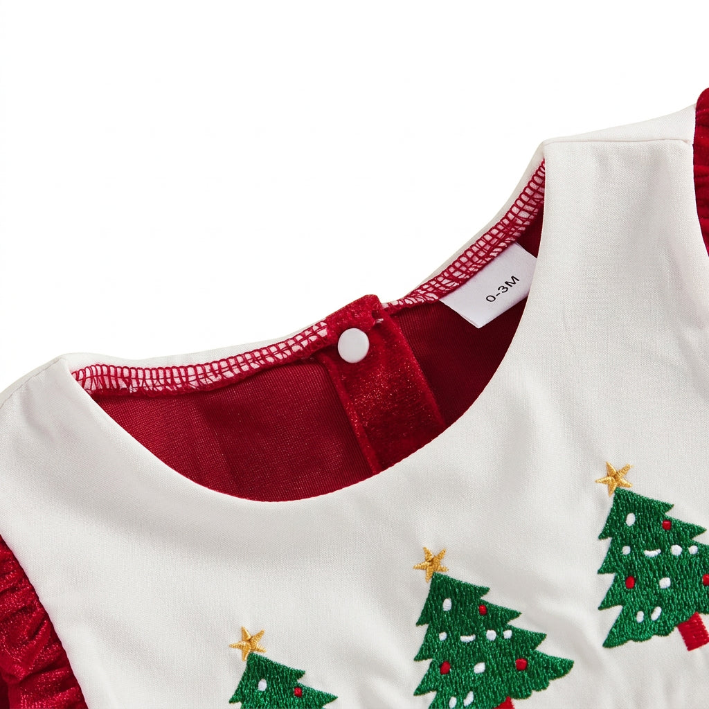 Close-up of white scalloped bib collar with embroidered green Christmas trees and back button closure
