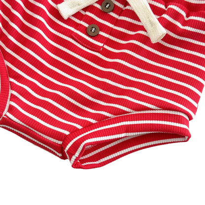 Close-up of baby girl red and white striped ribbed shorts featuring decorative brown buttons and a cream drawstring.
